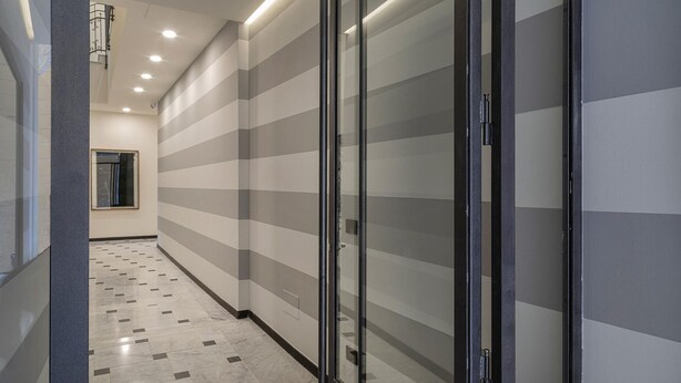 A hallway with striped walls, a glass door, and a tiled floor. - Riviera Flavour Apartments by Wonderful Italy - Alloro (Santa Margherita Ligure)