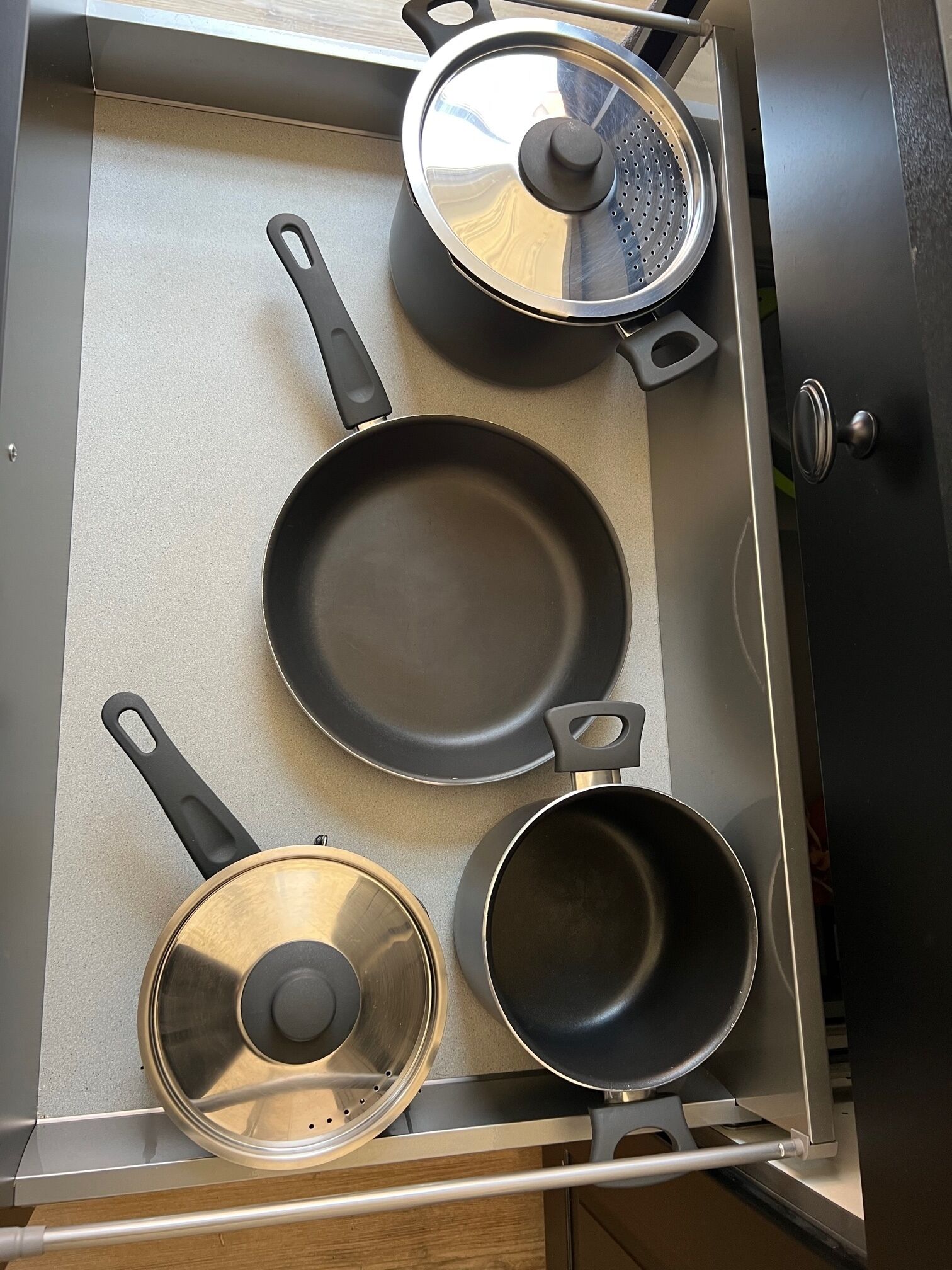 Una cocina con tres sartenes y una olla sobre la estufa.