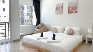 A modern bedroom with a large bed, a bean bag chair, and artwork on the wall. - BAOBAB (Patong)