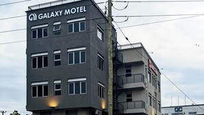 Un edificio de varios pisos con un cartel que indica el Galaxy Motel.