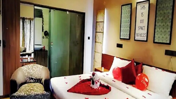 Une chambre d’hôtel avec un lit, une chaise, un bureau et une porte coulissante.