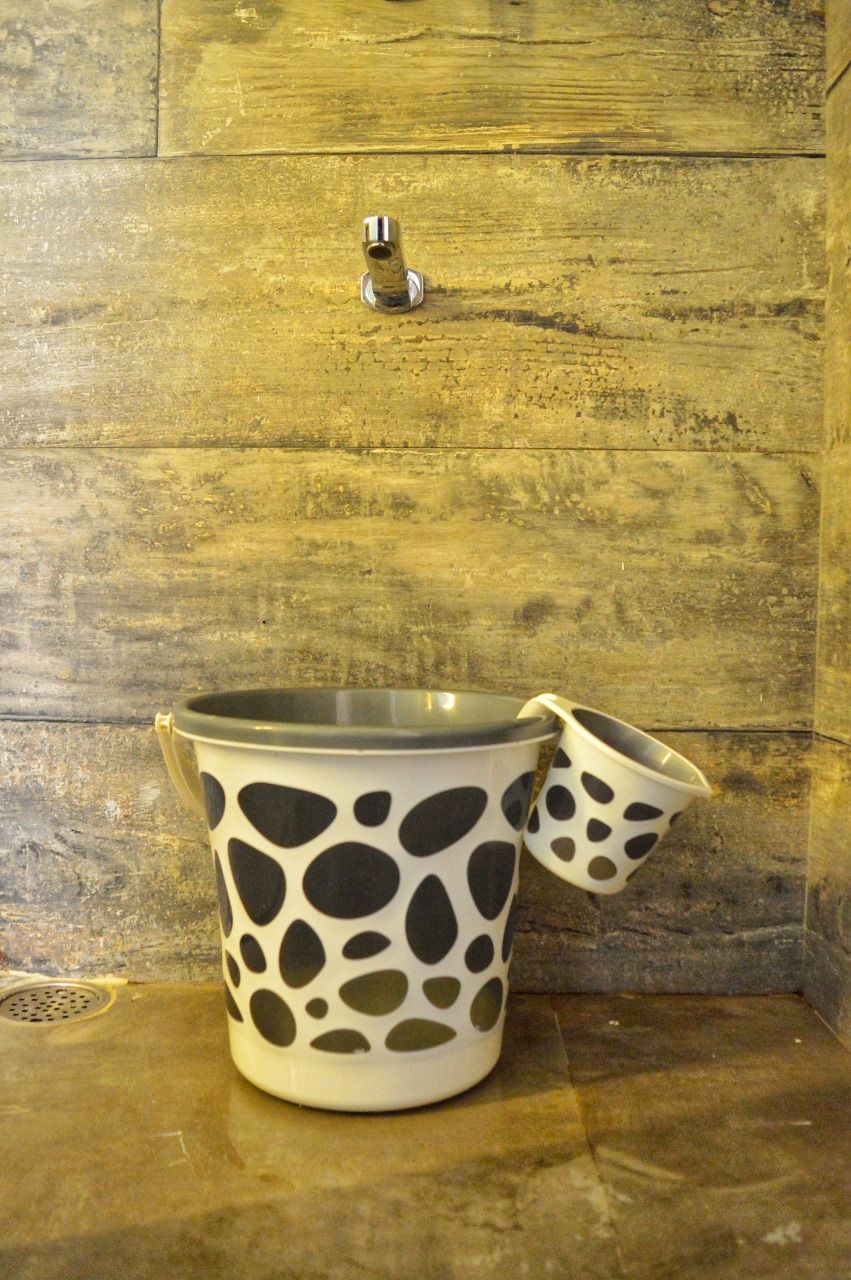 A white pot with black spots on a wooden surface.