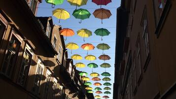 Une rue étroite, bordée de bâtiments des deux côtés, avec des parasols colorés suspendus au-dessus.