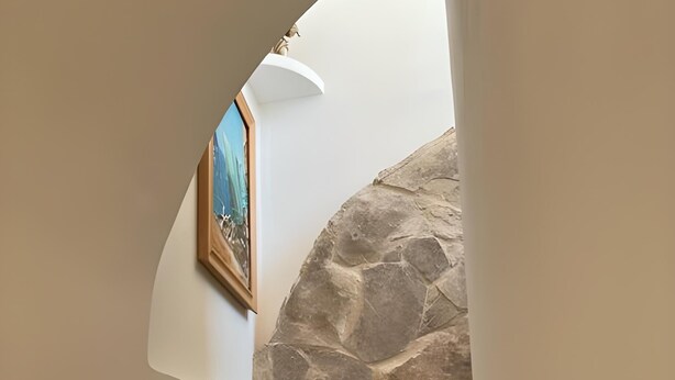 Una escala amb una paret de pedra i un quadre encimbellat a la pared.