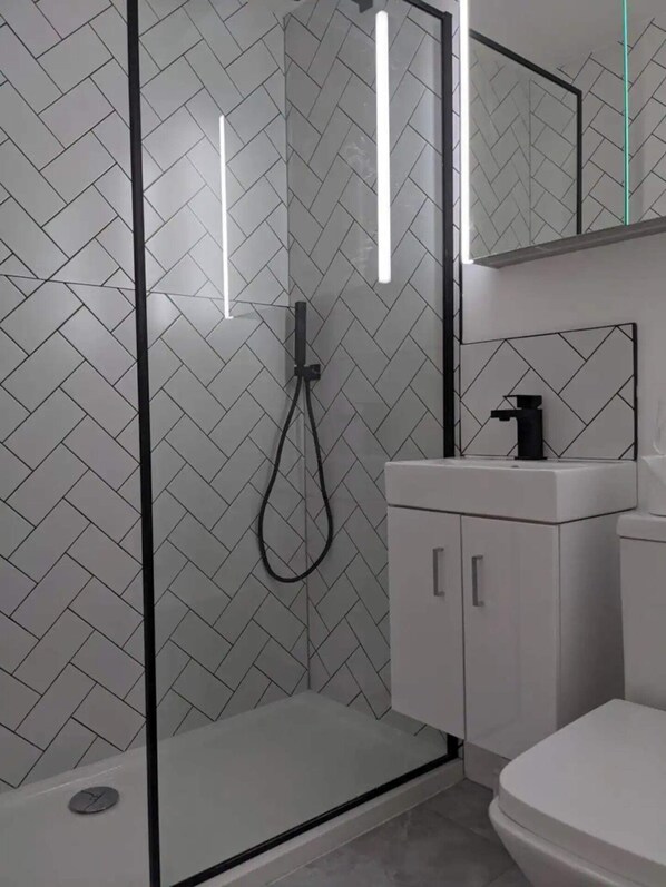 Departamento básico, 1 cama King size | Baño | Regadera, secadora de cabello, toallas, jabón 