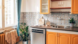 Eine Küche mit Geschirrspüler, Spüle und einem Schrank mit Glastüren.