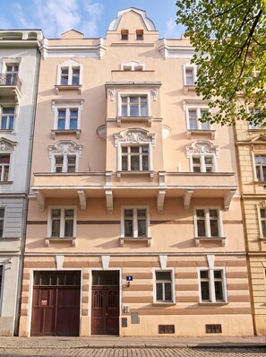 A multi-story building with a symmetrical facade, large windows, and a central entrance with double doors.