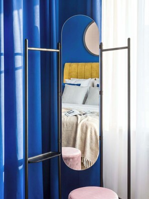 A room with a bed, a round mirror, and a black metal rack. - TurnKey | Florenc Studio by Central Bus Station (Praha 8)