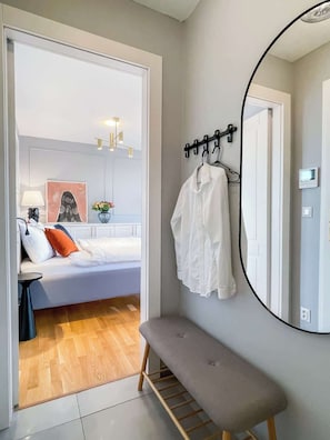 Une chambre à coucher avec un lit, une table de chevet, une lampe et un miroir fixé au mur.
