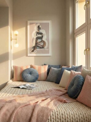 Un dormitorio con cama, almohadas, una obra de arte en la pared y una ventana.