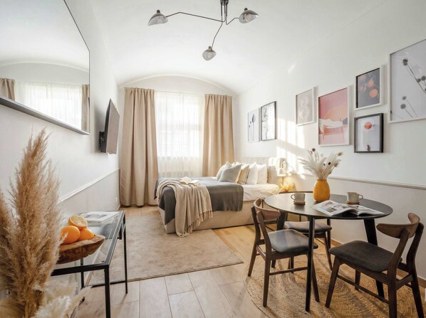 A modern bedroom with a bed, bedside table, and a large window with curtains.