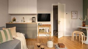 Una sala de estar moderna con un sofá, una mesa de centro y un televisor.