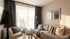 A living room with a sofa, coffee table, and a TV.
