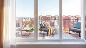 A balcony with a sofa, a table, and a chair. - TurnKey | Letna Park Apartment II –Premium Terrace (Praha 7)