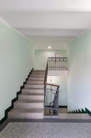 Una escalera con barandilla y un rellano con una puerta.
