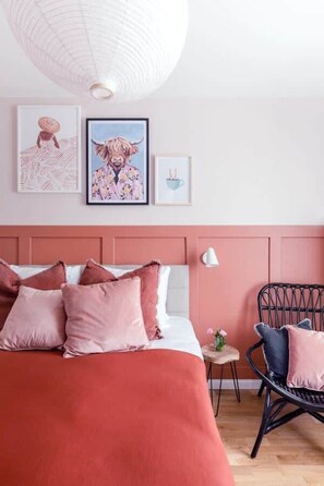 A bedroom with a bed, a chair, and wall art. - TurnKey | Letna Park  Apartment V – Cozy Terrace (Praha 7)