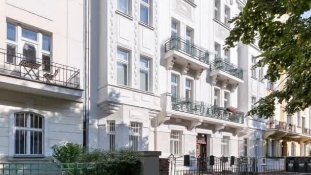 A multi-story building with a classical architectural style, featuring balconies and a red-tiled roof. - TurnKey | Stylish Studio by Letná Park w Balcony (Praha 7)