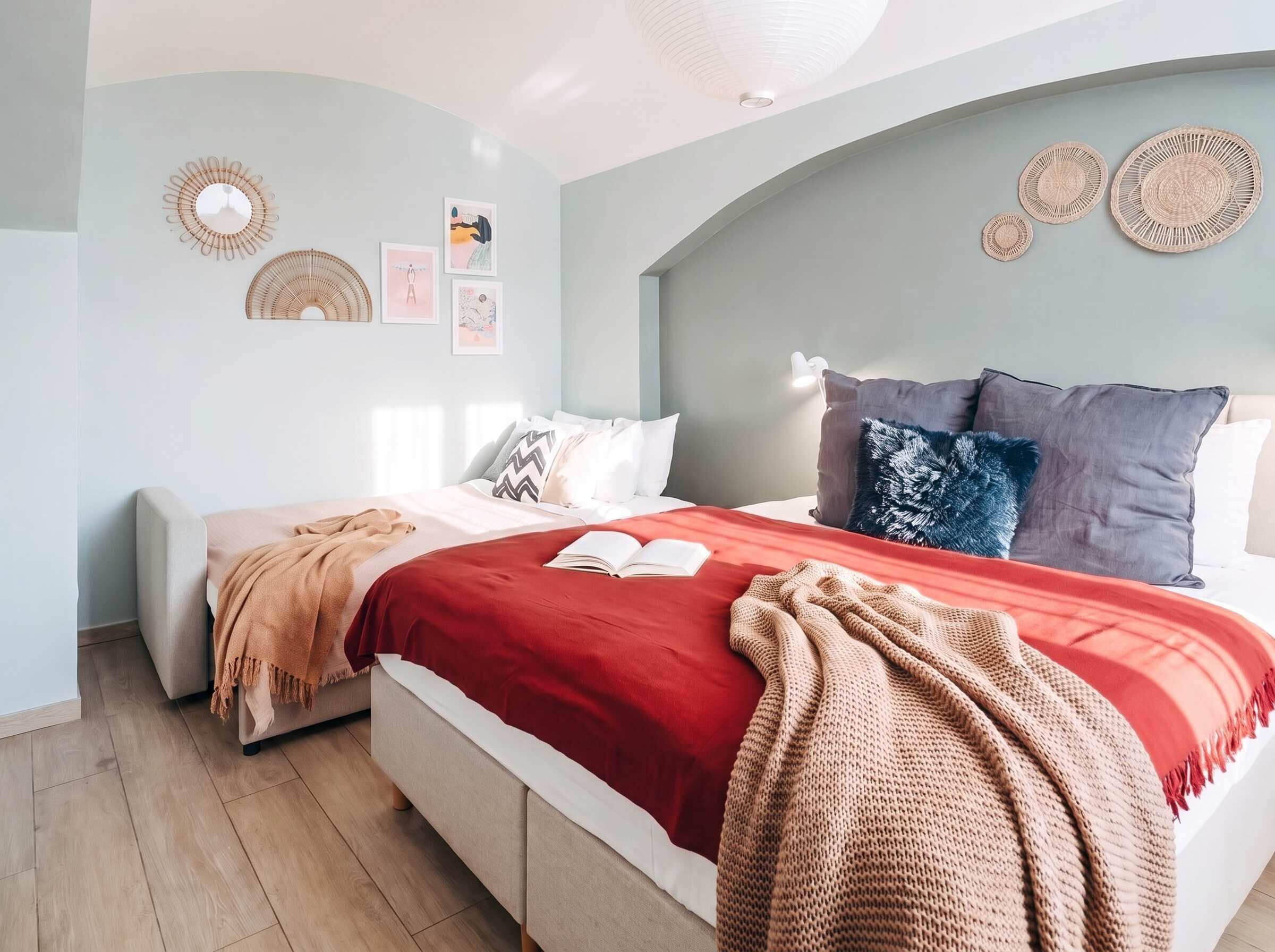 A bedroom with a bed, a bedside table, a lamp, and wall decorations.
