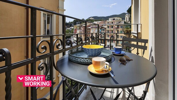 Ein Balkon mit Tisch, einer Kaffeetasse und einer Schüssel.