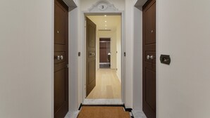 A hallway with two wooden doors, each with a number plate above. - Riviera Flavour Apartments by Wonderful Italy - Verbena (Santa Margherita Ligure)