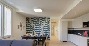 Eine moderne Wohnung mit Essbereich, Küche und Wohnzimmer mit Sofa.