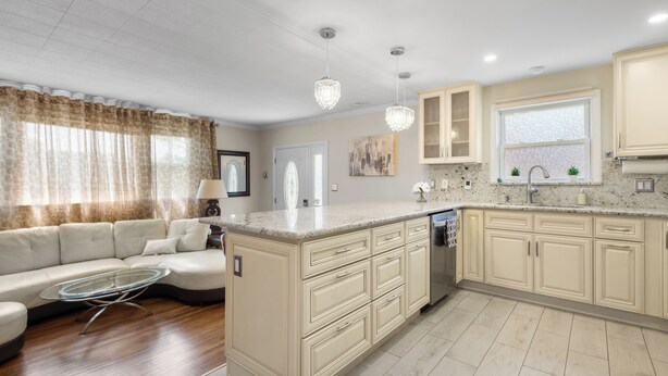 A modern kitchen with a central island, beige cabinetry, and pendant lighting. - Lansdale: Work, Rest, Explore (Lansdale)