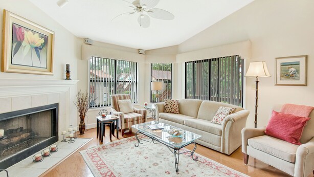 A spacious living room with a fireplace, a ceiling fan, and large windows. - Harbour Oaks 312 - 2Br/2Ba condo near Village (St. Simons Island)