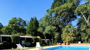 A rectangular swimming pool with a tiled edge, surrounded by a stone deck. There are two white lounge chairs and a metal pool ladder. - Spectacular Farm in Ibiúna (Ibiuna)