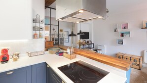 A modern kitchen with a built-in stove, wooden countertops, and a variety of kitchenware and decorations. - Astoria - baskeyrentals (San Sebastián)
