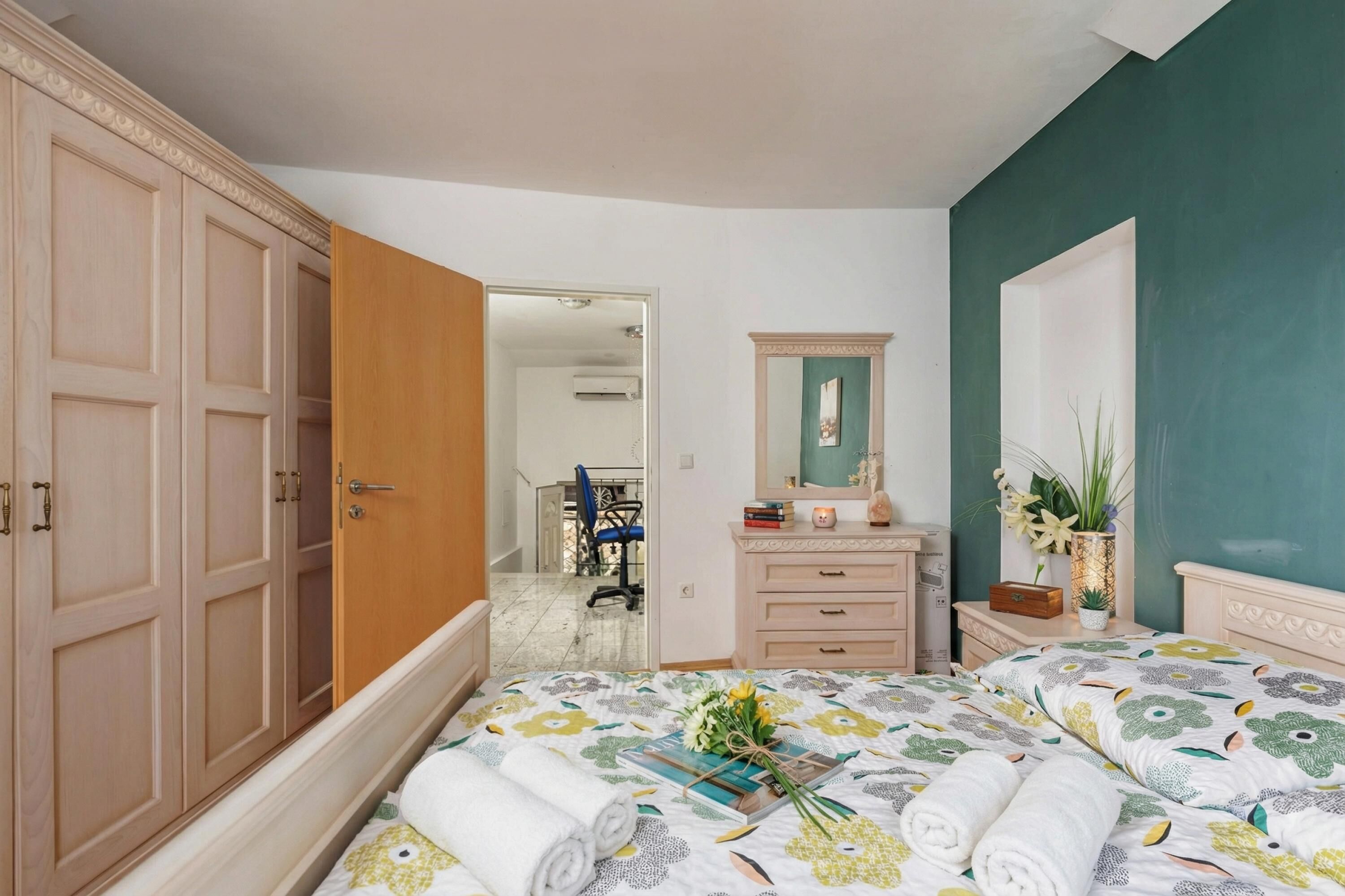 Une chambre à coucher avec un lit, une commode, un miroir et une armoire.