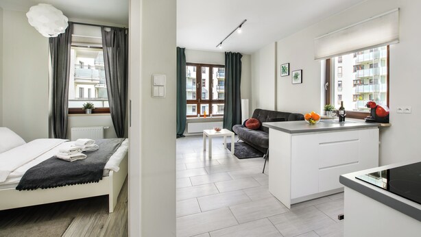 A modern apartment with a bed, a sofa, a dining area, and a kitchen. - Warsaw Night Apartments Giełdowa (Warsaw)