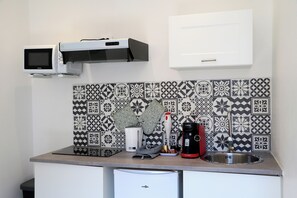 Eine Küche mit Mikrowelle, Kaffeemaschine und Spüle.