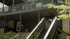 Un bâtiment à deux étages doté d’une terrasse en bois et d’un escalier menant à l’étage supérieur.