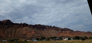 A mountainous landscape with a small settlement at its base, including buildings and vehicles. - SageCreek at Moab *Combined Two Unit Rental B* (Moab)