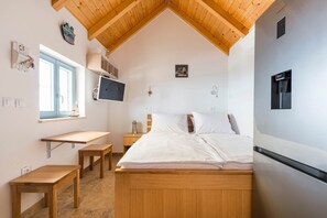 A bedroom with a bed, a desk, a chair, a TV, and a refrigerator. - House with a swimming pool - Olive Grove Sumartin (Sumartin)