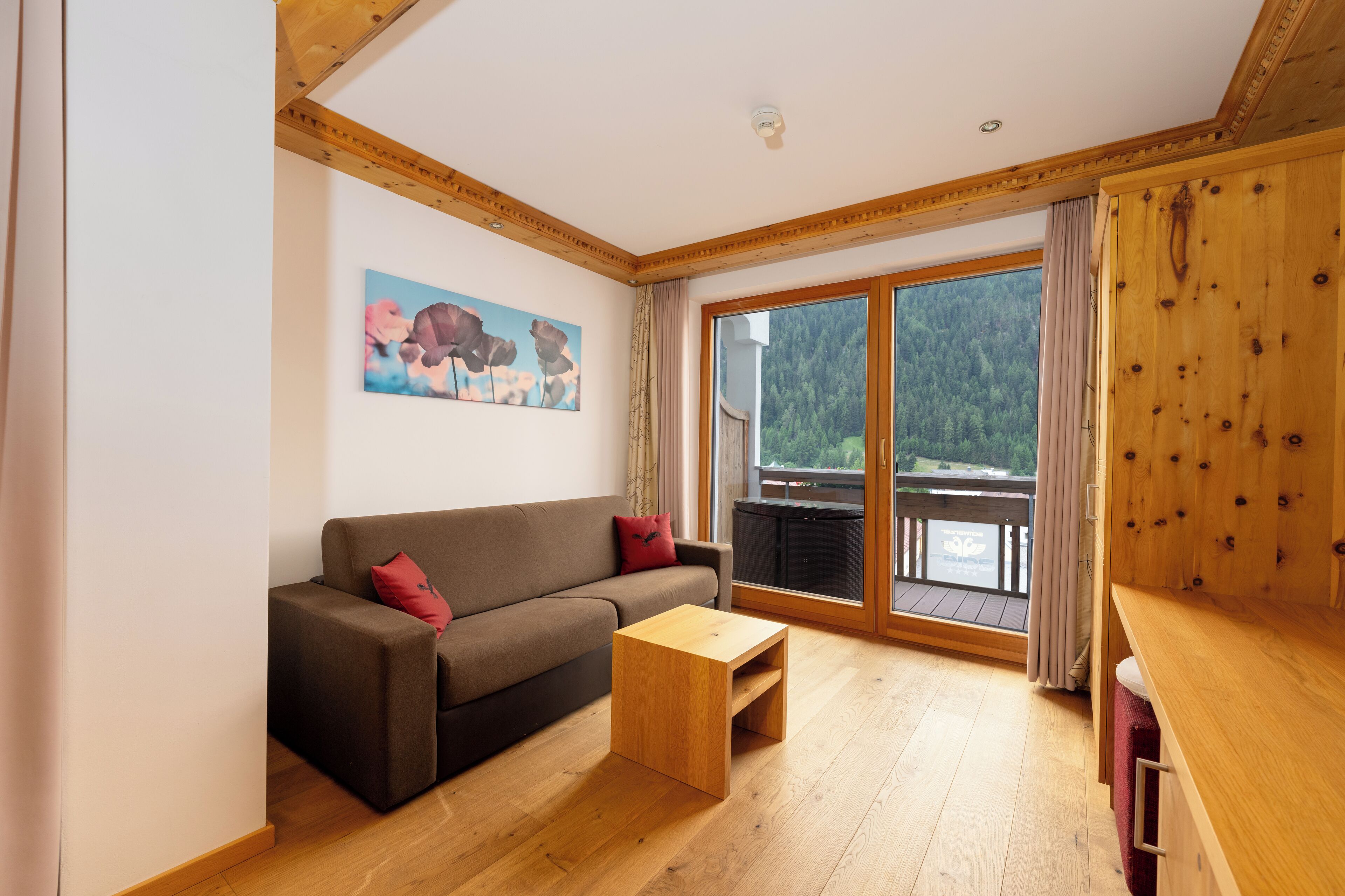 Una sala de estar moderna con un sofá marrón, una mesa de centro de madera y un cuadro en la pared.