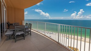 A balcony with a view of the ocean and beach, featuring a table and chairs. - Beautiful Beach Front Condo - Phoenix Gulf Towers 1203 (Orange Beach)