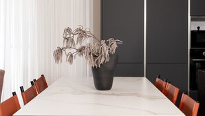 Une table à manger avec un pot de plante, entourée de chaises.