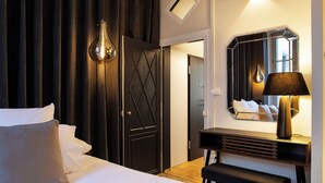 Une chambre d’hôtel avec un lit, un bureau, un miroir et une lampe.