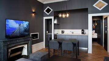 A modern living room with a fireplace, a television, and a dining area with chairs and a table.