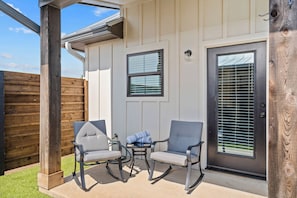 Relax in the outdoor seating area with a comfortable chair and table, perfect for taking in the surroundings.
