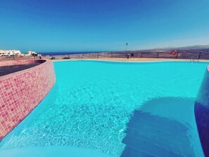 A clear blue pool with a tiled edge, a lifebuoy, and a fence in the background. - Casa Bella Vista - pool - WiFi - Table tennis  (Antigua)