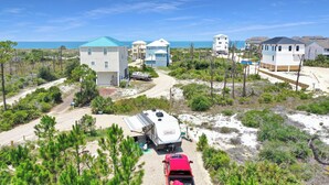 A coastal residential area with houses, a trailer, and a red vehicle.