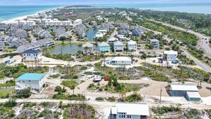 A coastal residential area with houses, a beach, and a lake.