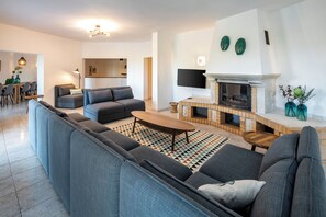 Relax in this stylish living room with a cozy fireplace, comfortable sofa, and flat-screen TV.
