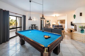 Relax in style with a pool table, comfortable sofa, and fireplace in this inviting indoor recreational area.