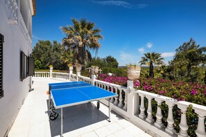 Relax on the balcony overlooking a lush garden with a ping pong table at the ready.