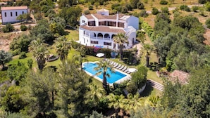 A large white villa with a swimming pool surrounded by lush greenery and a hilly landscape. - Villa Luz 21, Ruime Villa met Privé Zwembad (Silves)