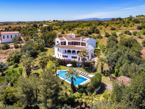 Experience serene living in this two-story villa, surrounded by lush gardens and a pool.