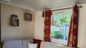 A cozy living room with a sectional sofa, a wooden coffee table, and a window with curtains.